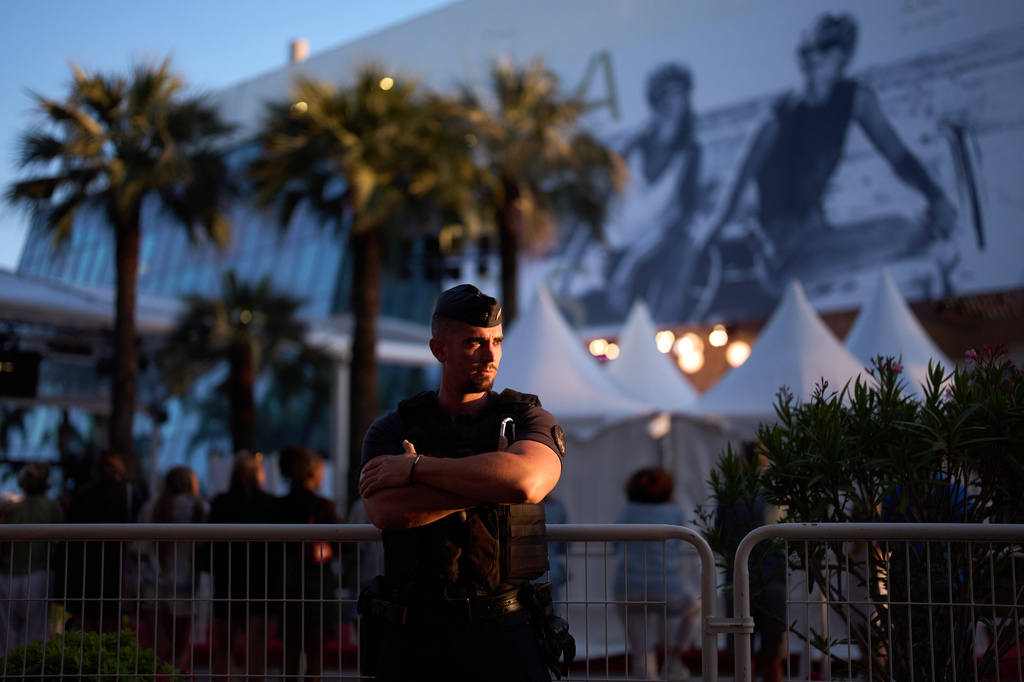 A police officer stands long the road near the red carpet during the 79th international film festival, Cannes, southern France, Wednesday, May 13, 2026. (AP Photo/John Locher)