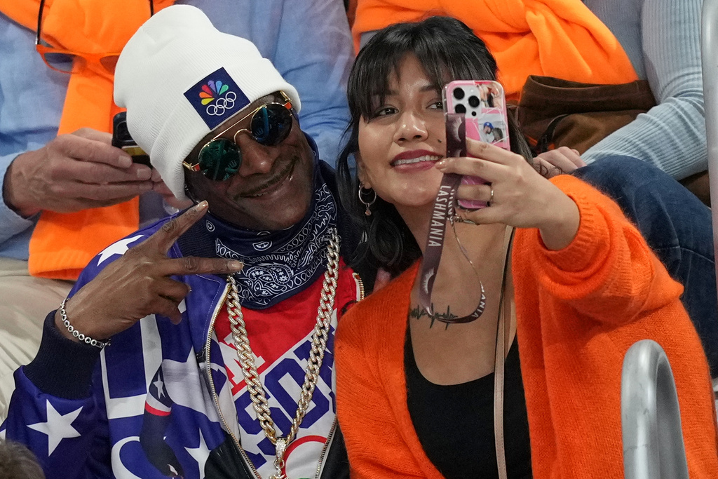 Snoop Dogg poses for a selfie as he watches the women's 500 meters speedskating race at the 2026 Winter Olympics, in Milan, Italy, Sunday, Feb. 15, 2026. (AP Photo/Antonio Calanni)