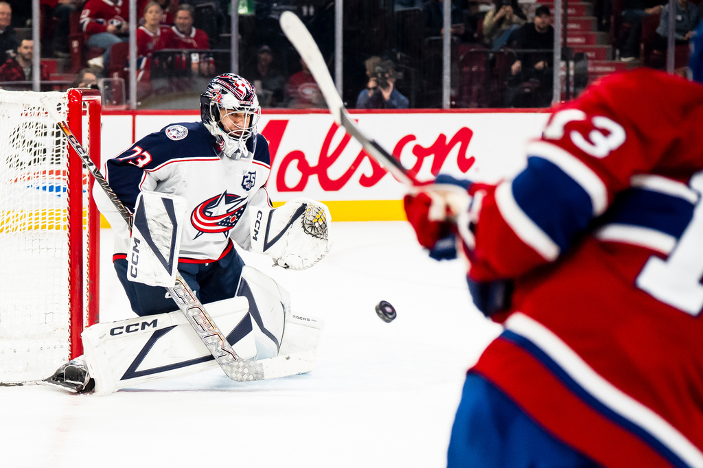 Columbus Blue Jackets' Jet Greaves (73) makes a save against Montreal Canadiens' Cole Caufield (13) during first-period NHL hockey game action in Montreal, Saturday, April 11, 2026. (Christopher Katsarov/The Canadian Press via AP)