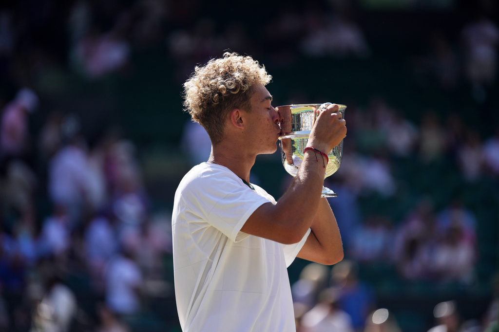 Jordan Lee of the United States kisses the trophy after winning against Cruz Hewitt of Australia in the boy's singles final at the Wimbledon Tennis Championships in London, Sunday, July 12, 2026. (AP Photo/Brian Inganga)