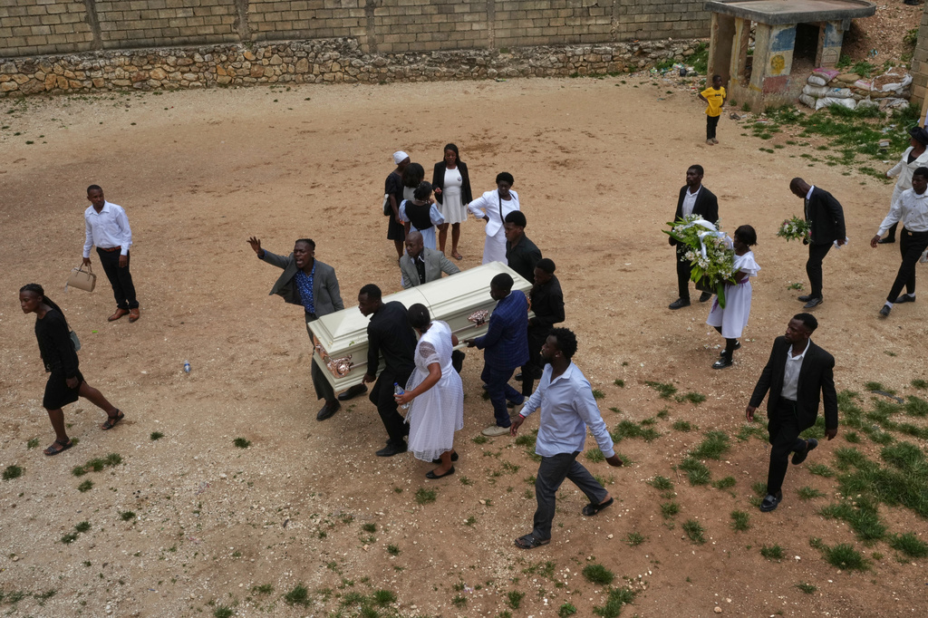 Relatives carry a coffin to the cemetery for burial after the funeral ceremony for four victims killed in a gang attack on the Kenscoff neighborhood of Port-au-Prince, Haiti, Sunday, Aug. 30, 2026. (AP Photo/Odelyn Joseph)