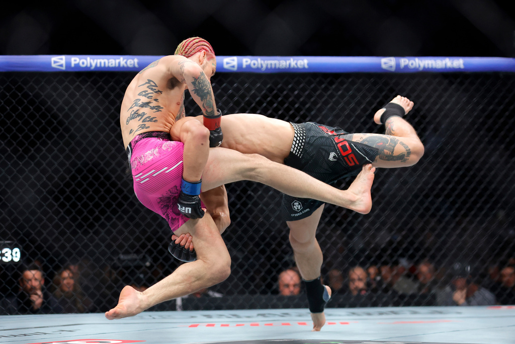 Sean O'Malley, left, is taken down by Song Yadong, right, in a bantamweight bout during the UFC 324 mixed martial arts event Saturday, Jan. 24, 2026, in Las Vegas. (AP Photo/Steve Marcus)