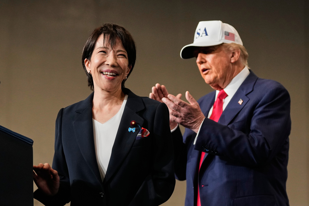 Japanese Prime Minister Sanae Takaichi, with President Donald Trump, reacts as she was speaking to members of the military aboard the USS George Washington, an aircraft carrier docked at an American naval base, in Yokosuka, Tuesday, Oct. 28, 2025. (AP Photo/Mark Schiefelbein)