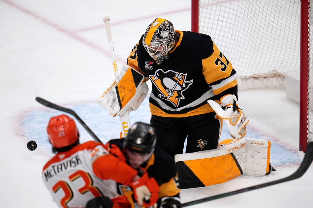 Pittsburgh Penguins goaltender Arturs Silovs (37) blocks a shot by Anaheim Ducks' Mason McTavish (23) during the first period of an NHL hockey game, in Pittsburgh, Tuesday, Dec. 9, 2025. (AP Photo/Gene J. Puskar)