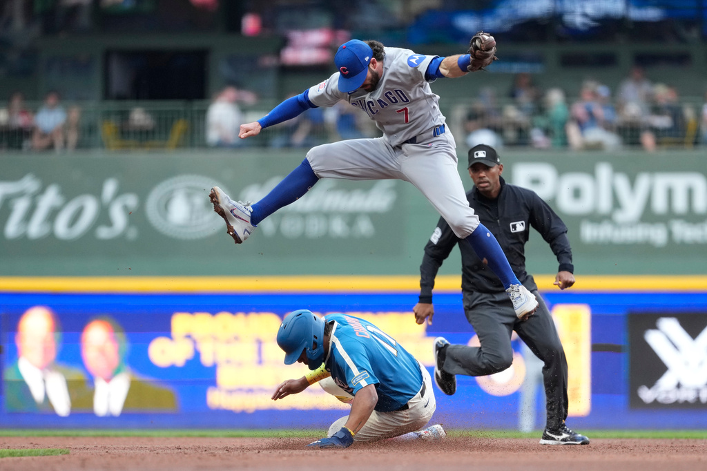 Milwaukee Brewers' Jackson Chourio, bottom, steals second base as Chicago Cubs' Dansby Swanson (7) leaps to catch the ball during the third inning of a baseball game Saturday, June 27, 2026, in Milwaukee. (AP Photo/Aaron Gash)