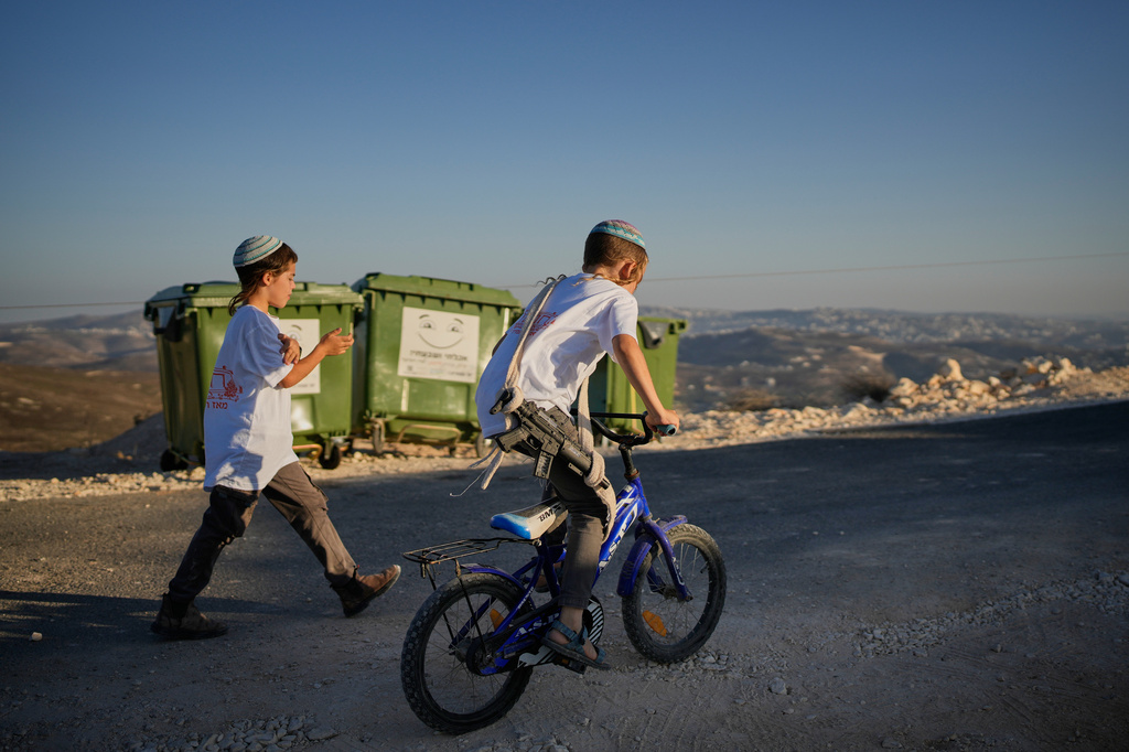 A young Israeli settler carries a toy gun during the inauguration of a newly built synagogue at the West Bank outpost of Homesh, Wednesday, Sept. 16, 2026. (AP Photo/Ohad Zwigenberg)