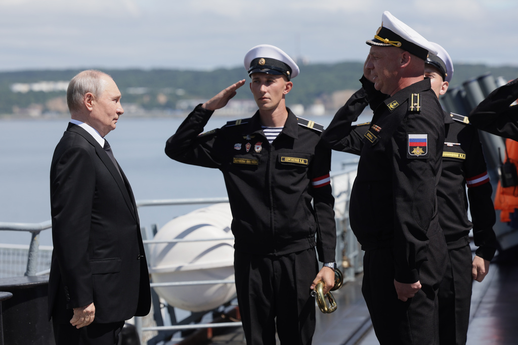 Russian President Vladimir Putin, left, visits the Varyag missile cruiser of the Pacific Fleet to watch a military exercise near Yuzhno-Sakhalinsk, on Sakhalin Island, Russia, Wednesday, Aug. 12, 2026. (Gavriil Grigorov, Sputnik, Kremlin Pool Photo via AP)