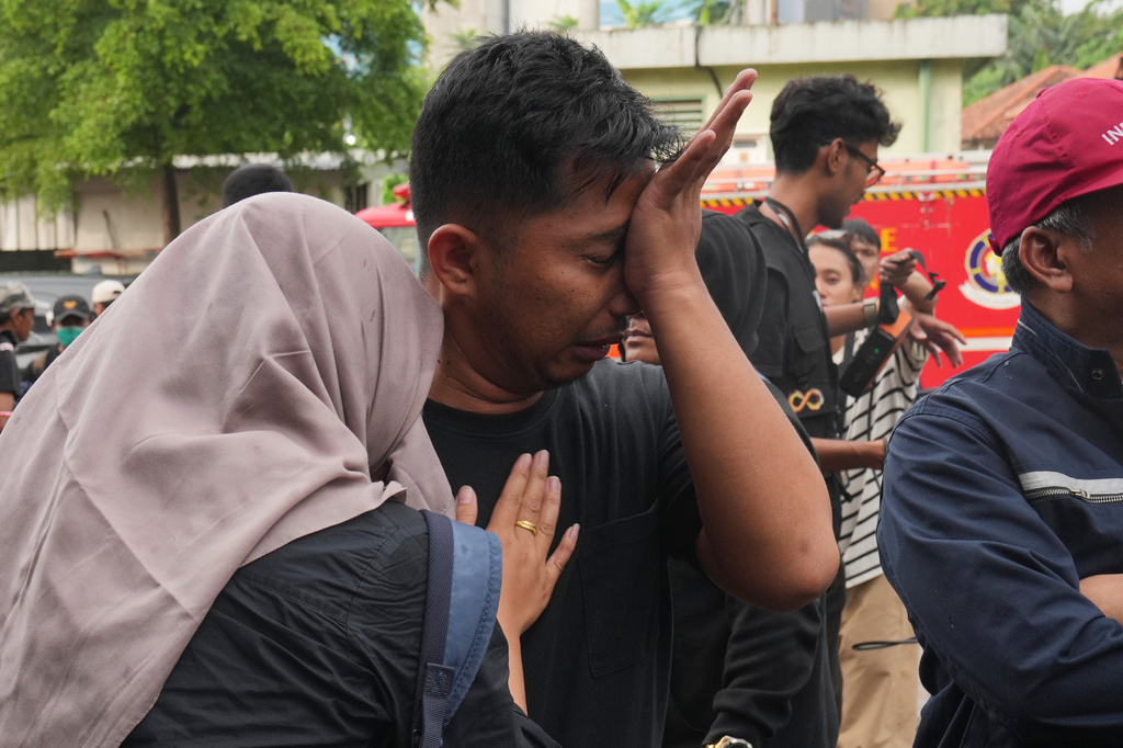 A relative of a victim of a train collision weeps in Bekasi, Indonesia, Tuesday, April 28, 2026. (AP Photo/Tatan Syuflana)