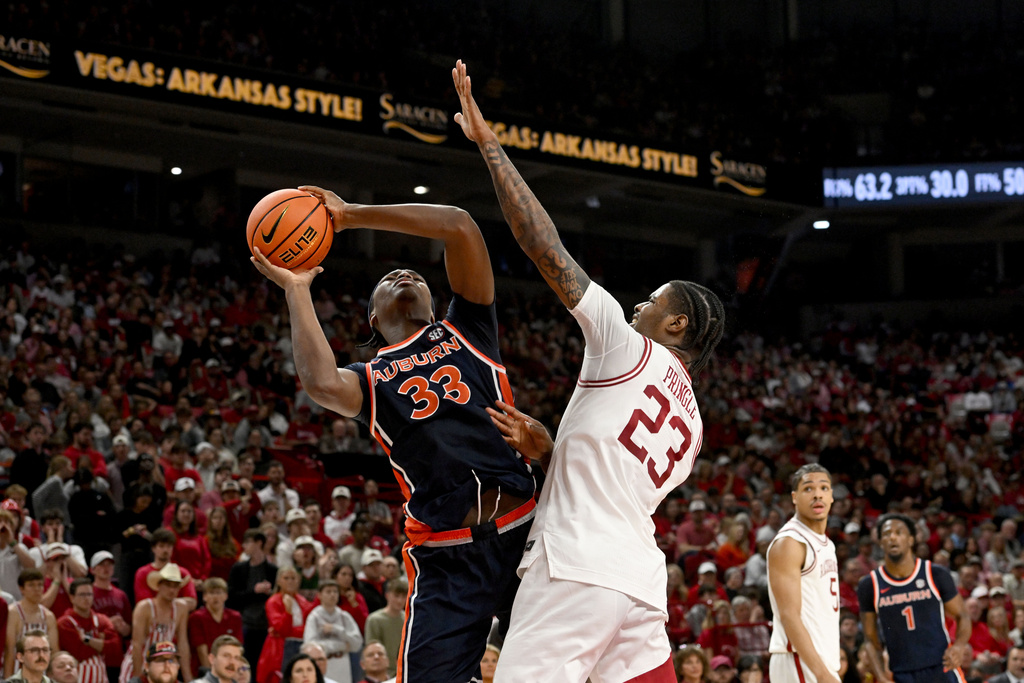 Auburn forward Sebastian Williams-Adams (33) shoots over Arkansas forward Nick Pringle (23) during the first half of an NCAA college basketball game Saturday, Feb. 14, 2026, in Fayetteville, Ark. (AP Photo/Michael Woods)