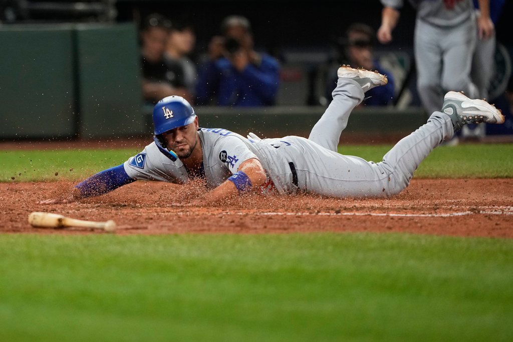 Los Angeles Dodgers' Michael Conforto slides home to score off an RBI single hit by Dalton Rushing during the sixth inning of a baseball game against the Seattle Mariners, Friday, Sept. 26, 2025, in Seattle. (AP Photo/Ryan Sun)