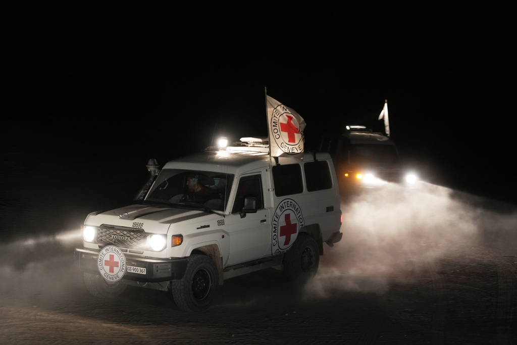 Red Cross vehicles carrying the bodies of three people believed to be deceased hostages handed over by Hamas make their way toward the border crossing with Israel, to be transferred to Israeli authorities, in Deir al-Balah, central Gaza Strip, Sunday, Nov. 2, 2025. (AP Photo/Jehad Alshrafi)