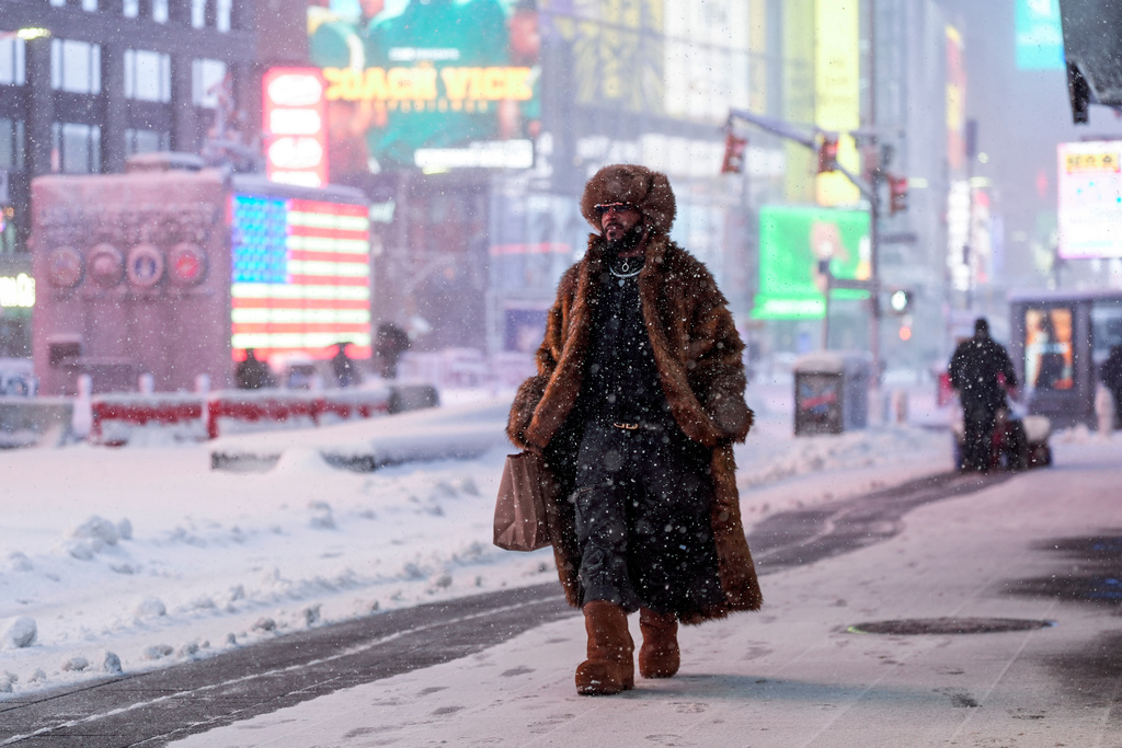 A man walks through Times Square during a snow storm, Monday, Feb. 23, 2026, in New York. (AP Photo/Seth Wenig)