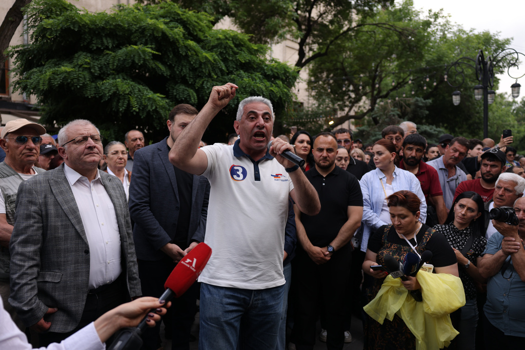 A man gestures speaking to demonstrators of opposition parties, in protest of the results of the parliamentary elections in Yerevan, Armenia, Sunday, June 14, 2026. (AP Photo/Anthony Pizzoferrato)