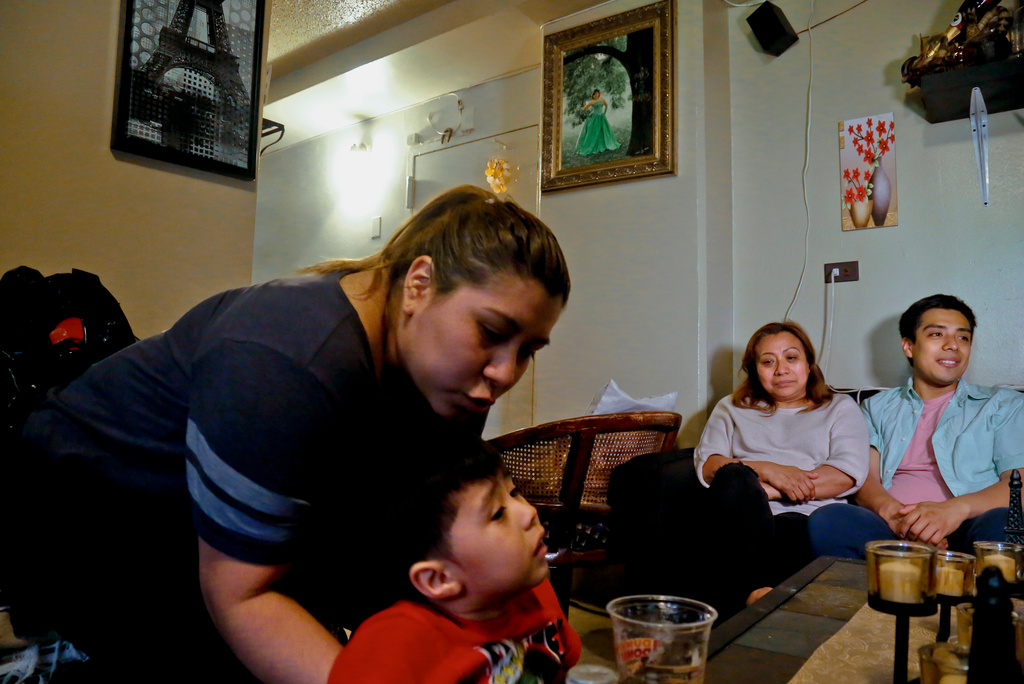 FILE PHOTO - Rosa, second from right, who wants her last name withheld, an undocumented immigrant who used to get about $190 per month from the Supplemental Nutrition Assistance Program, or SNAP, and who stopped taking benefits fearing deportation, is surrounded by her son Edgar, far right, daughter Olga, far left, and grandson Logan at their home during an interview in New York, May 17, 2017. (AP Photo/Bebeto Matthews, File)