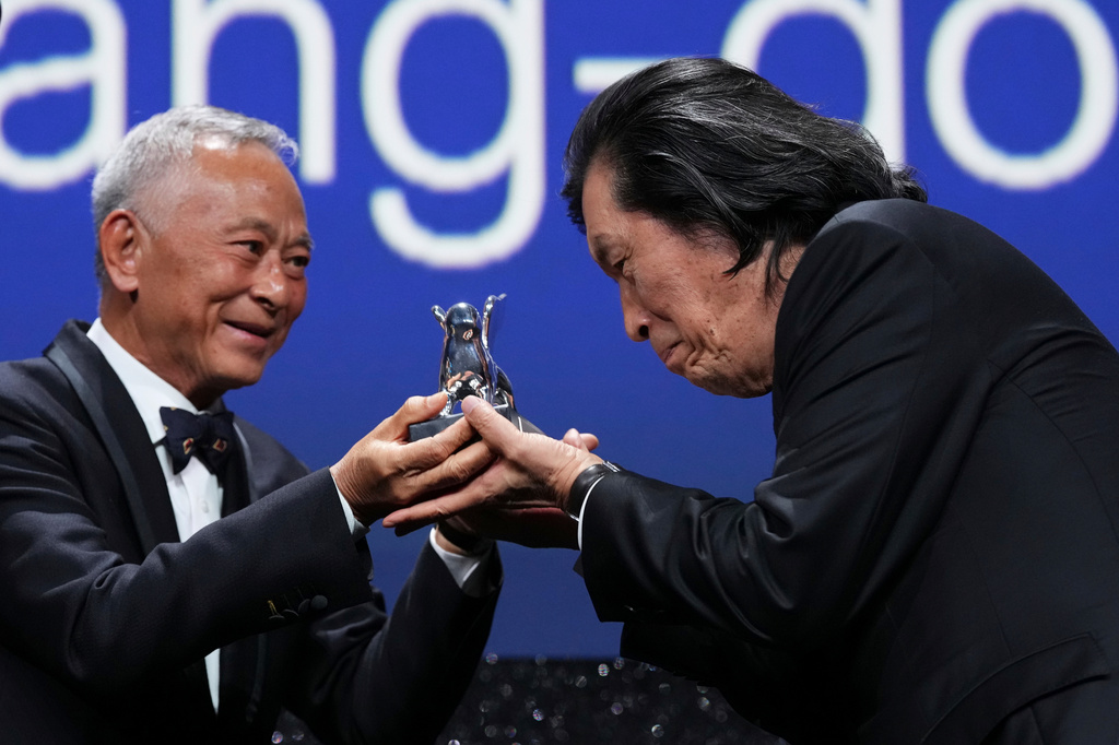 Jury member Johnnie To, left, presents director Lee Chang-dong the grand jury prize for the film 'Possible Love' during the closing ceremony of the 83rd edition of the Venice Film Festival in Venice, Italy, on Saturday, Sept. 12, 2026. (Photo by Scott A Garfitt/Invision/AP)
