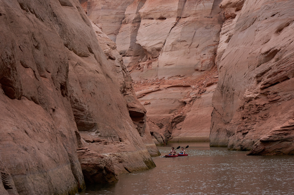 People paddle through a canyon on Lake Powell at the Glen Canyon National Recreation Area, Wednesday, July 15, 2026, near Page, Ariz. (AP Photo/John Locher)