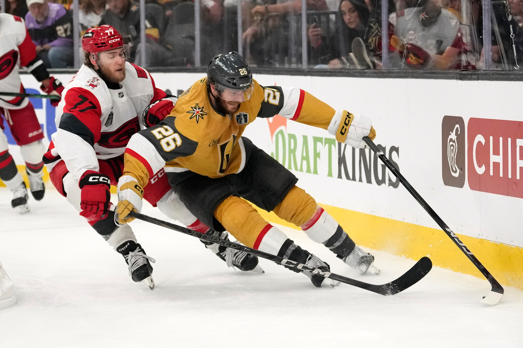 Carolina Hurricanes left wing Mark Jankowski, left, and Vegas Golden Knights center Nic Dowd battle for the puck during overtime in Game 3 of the NHL hockey Stanley Cup Final series Saturday, June 6, 2026, in Las Vegas. (AP Photo/John Locher)