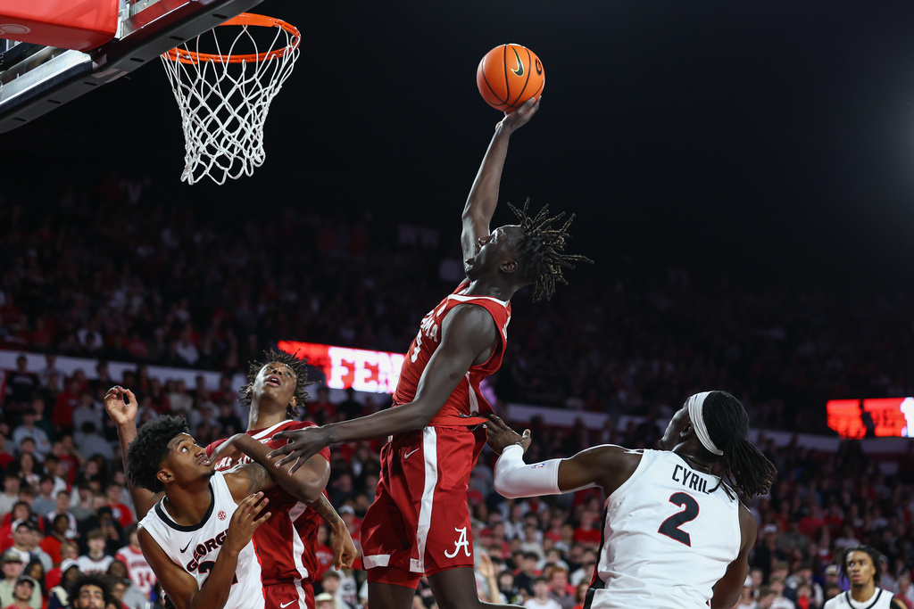 Alabama forward Taylor Bol Bowen, center, shoots against Georgia forward Jake Wilkins, left, and center Somto Cyril (2) during the first half of an NCAA college basketball game, Tuesday, March. 3, 2026, in Athens, Ga. (AP Photo/Colin Hubbard)