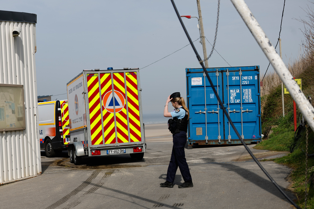 A police officer stands guard after at least four people died while trying to board an inflatable boat for a dangerous sea crossing from northern France to the U.K. in Equihen-Plage, northern France. Thursday, April 9, 2026. (AP Photo/Jean-Francois Badias)