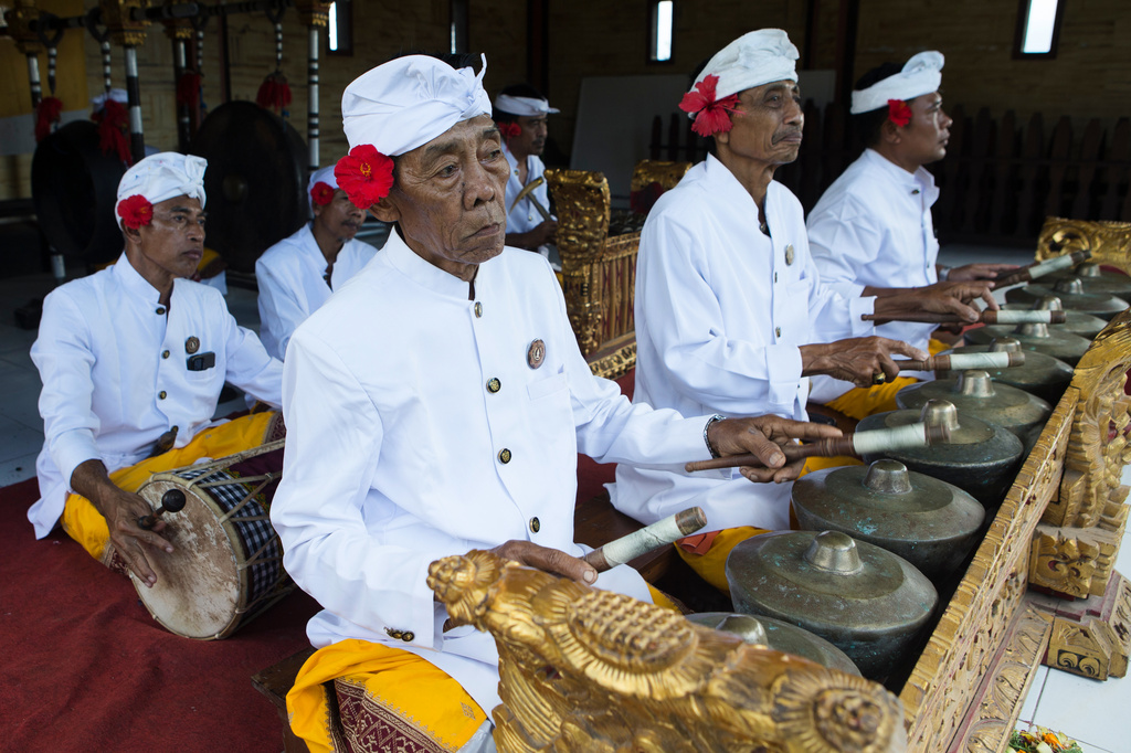 Balinese men plays traditional musical instruments during the performance of the sacred Rejang dance during Kuningan holiday, which marks the end of the 10-day Galungan festival celebrating the victory of good over evil, in Karangasem, Bali, Indonesia, Saturday, June 27, 2026. (AP Photo/Firdia Lisnawati)
