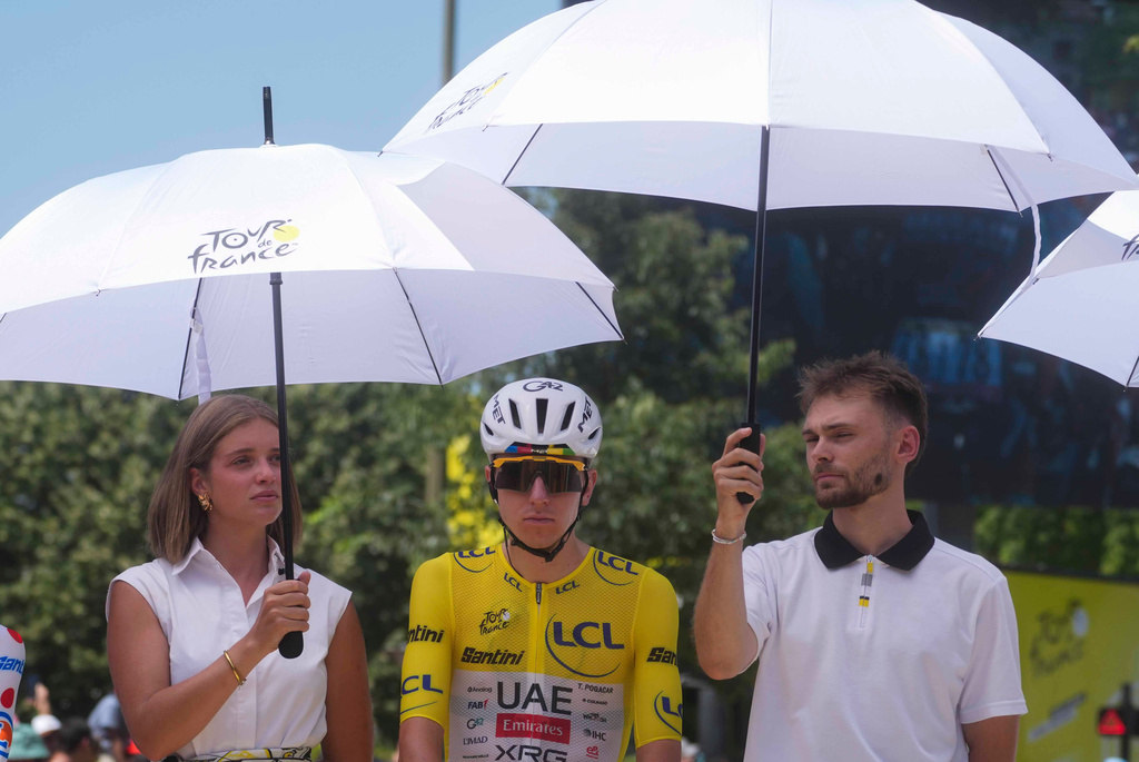 Slovenia's Tadej Pogacar wearing the overall leader's yellow jersey, is shielded from the sun ahead of the start of the eighth stage of the Tour de France cycling race of over 180.4 kilometers (about 1120 miles) with start in Perigueux and finish in Bergerac, France, Saturday, July 11, 2026. (AP Photo/Thibault Camus)