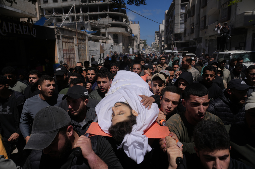 Mourners carry the body of Azzam al-Hayya, son of Hamas leader Khalil al-Hayya, mourn over his body after he was killed in an Israeli airstrike, at Shifa Hospital in Gaza City Thursday, May 7, 2026. (AP Photo/Jehad Alshrafi)