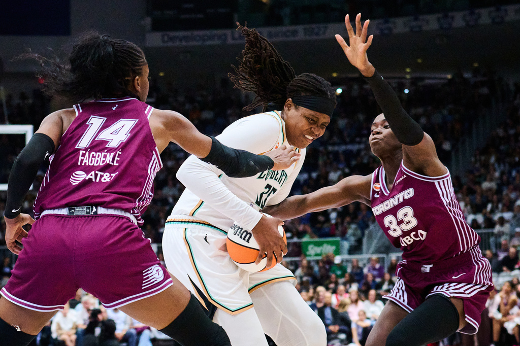 New York Liberty's Jonquel Jones (35) drives to the net through Toronto Tempo's Temi Fagbenle (14), left, and Ornella Bankole (33) during the first half of a WNBA basketball game in Toronto, Sunday, Sept. 20, 2026. (Sammy Kogan/The Canadian Press via AP)