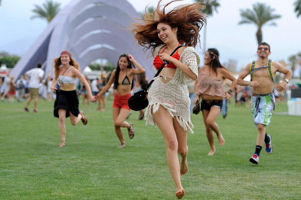 FILE - Festivalgoers run toward the main stage at the Coachella Valley Music and Arts Festival in Indio, Calif., on April 13, 2012. (AP Photo/Chris Pizzello, File)