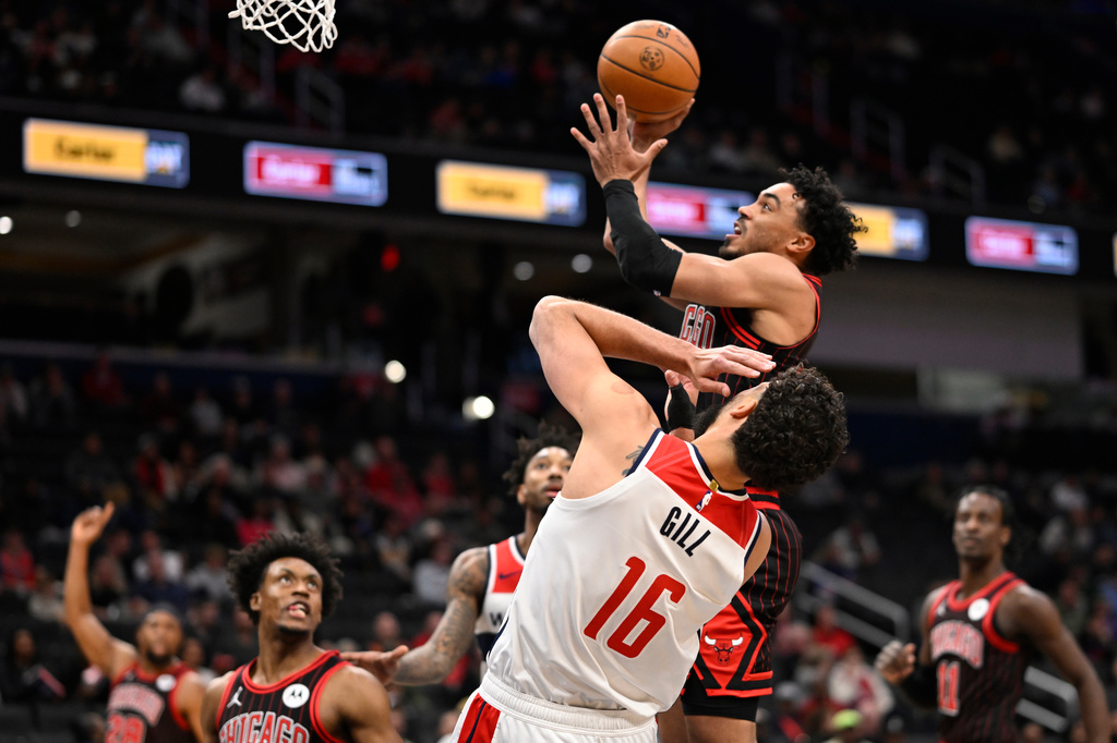 Chicago Bulls guard Tre Jones goes to shoot against Washington Wizards forward Anthony Gill (16) during the first half of an NBA basketball game, Tuesday, April 7, 2026, in Washington. (AP Photo/John McDonnell)