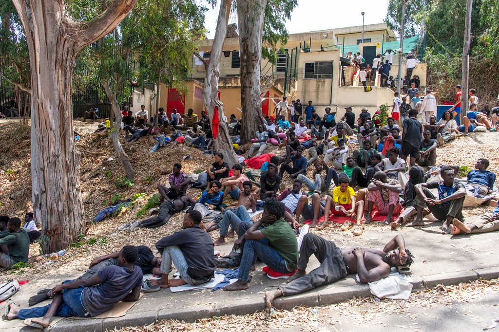 Migrants rest outside the Temporary Center for Immigrants (CETI) after crossing from Morocco into the Spanish enclave of Ceuta, Friday, July 31, 2026. CETI is the Spanish acronym for the migrant reception center. (AP Photo/Antonio Sempere)