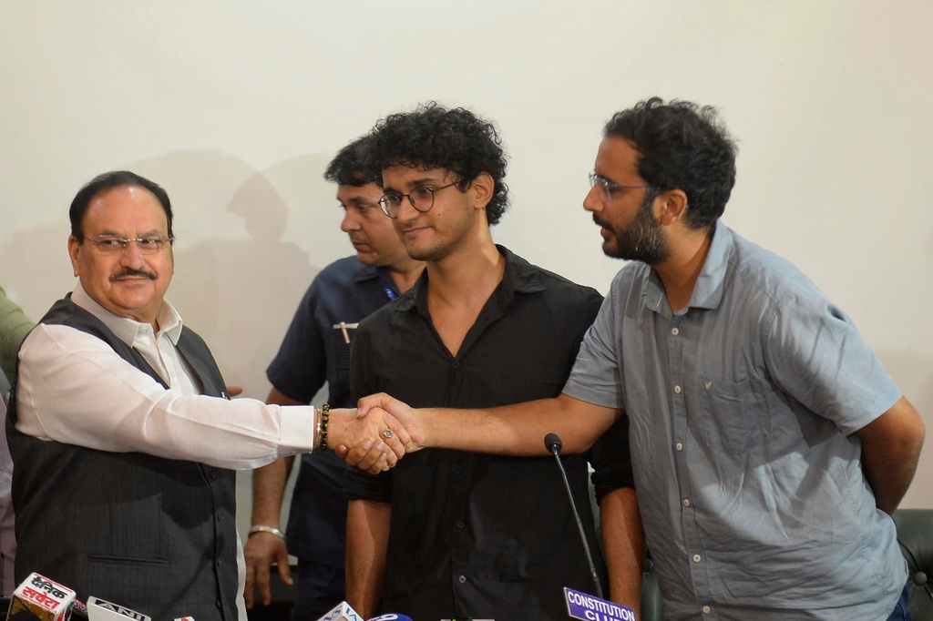 FILE -Saurav Das, chief spokesperson of the Cockroach Janta Party, center, looks on as fellow spokesperson Ashutosh Ranka, right, shakes hands with India's Health Minister J.P. Nadda during a joint press conference in New Delhi, India, July 25, 2026, following the resignation of India's education minister. (AP Photo, File)