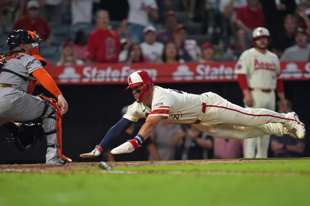 Los Angeles Angels' Mike Trout (27) scores on Jorge Soler's double as Houston Astros' Christian Vazquez (2) awaits the throw during the fifth inning of a baseball game Tuesday, July 28, 2026, in Anaheim, Calif. (AP Photo/Scott Strazzante)