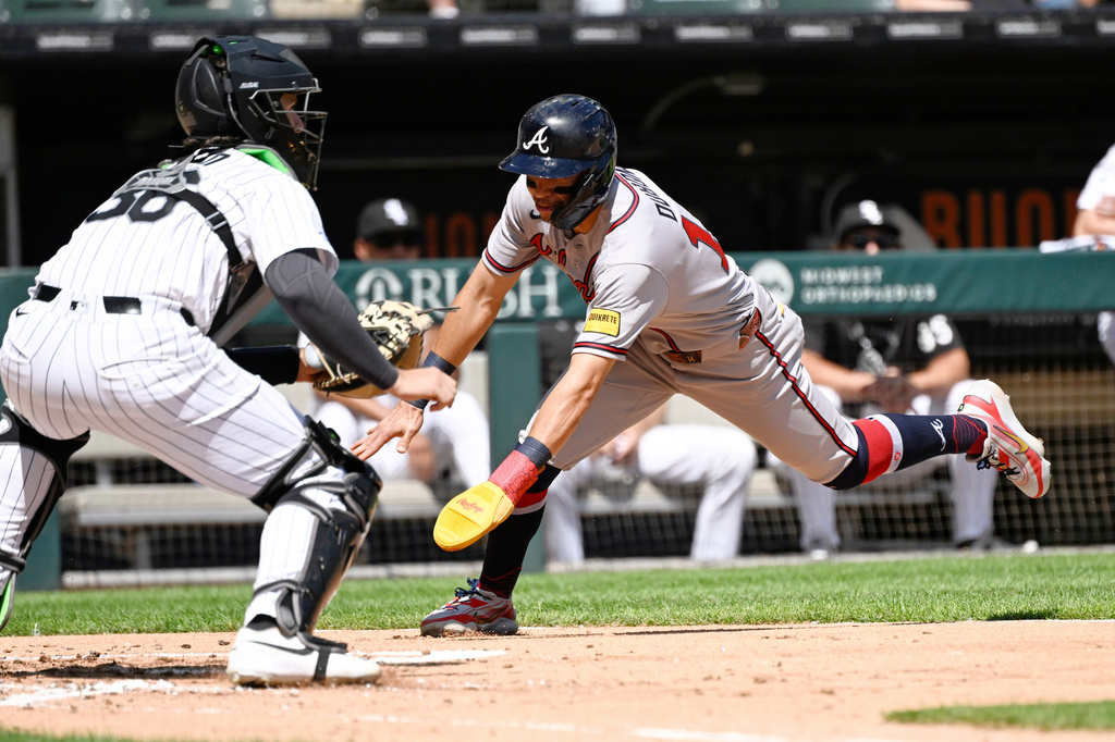 Atlanta Braves' Mauricio Dubón, right, scores past Chicago White Sox catcher Drew Romo (36) during the third inning of a baseball game, Thursday, Aug. 20, 2026, in Chicago. (AP Photo/Matt Marton)