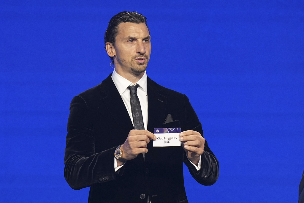 Former soccer star Zlatan Ibrahimovic displays Club Brugge during the Champions League soccer league phase draw in Monaco, Thursday, Aug. 28, 2025. (AP Photo/Laurent Cipriani)
