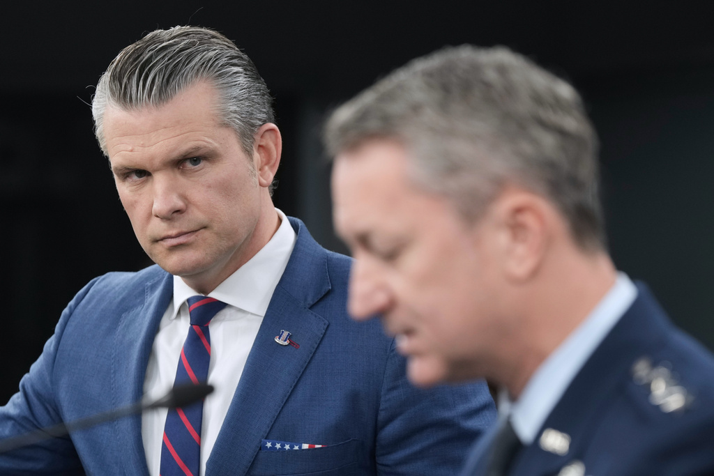 Defense Secretary Pete Hegseth listens to Chairman of the Joint Chiefs of Staff Gen. Dan Caine, during a press briefing at the Pentagon, Monday, March 2, 2026, in Washington. (AP Photo/Mark Schiefelbein)