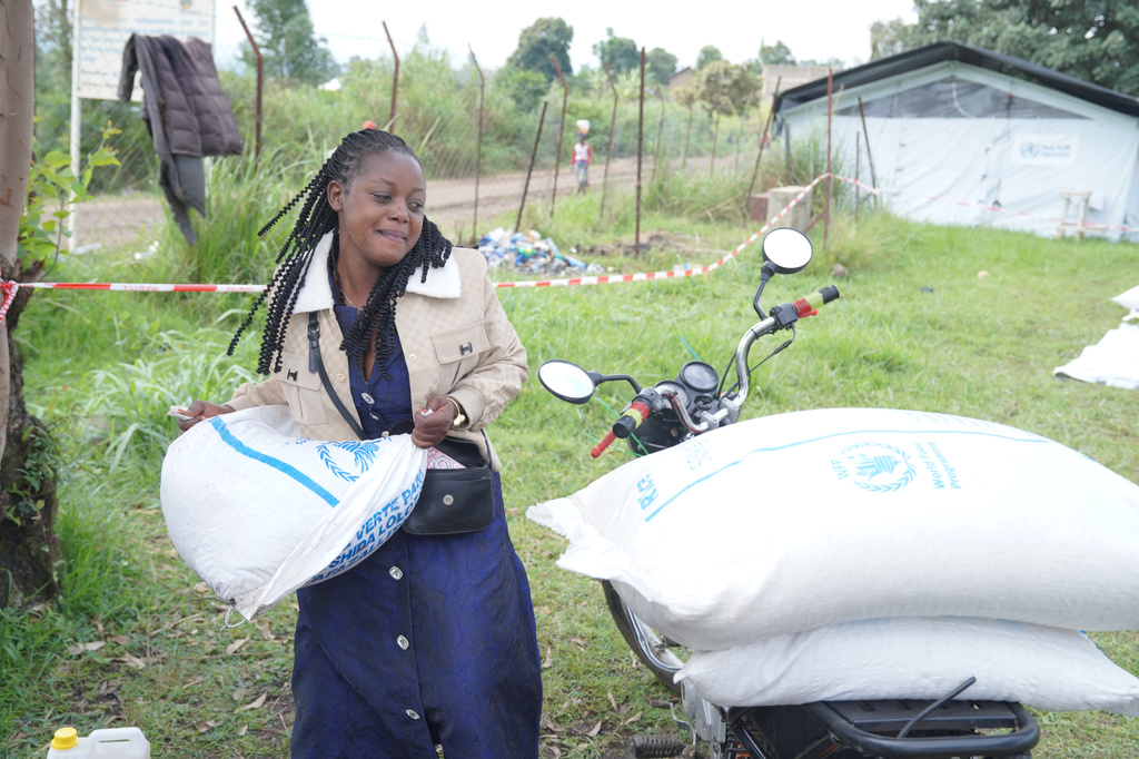 A woman collects a food donation from the World Food Programme at the Rwampara Ebola treatment center in Ituri, eastern Congo, Wednesday, July 29, 2026. (AP Photo/Dieudonne Dirole)
