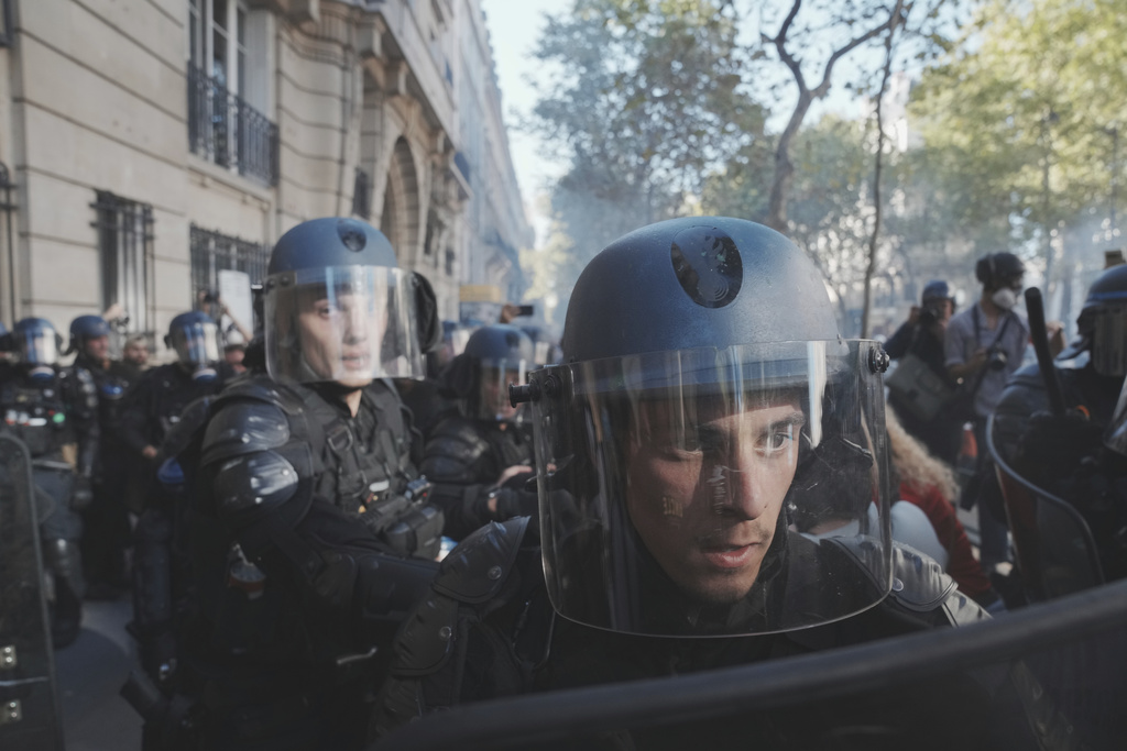 Police officers face protesters during a demonstration called by major trade unions to oppose budget cuts, in Paris, France, Thursday, Sept. 18, 2025. (AP Photo/Thibault Camus)