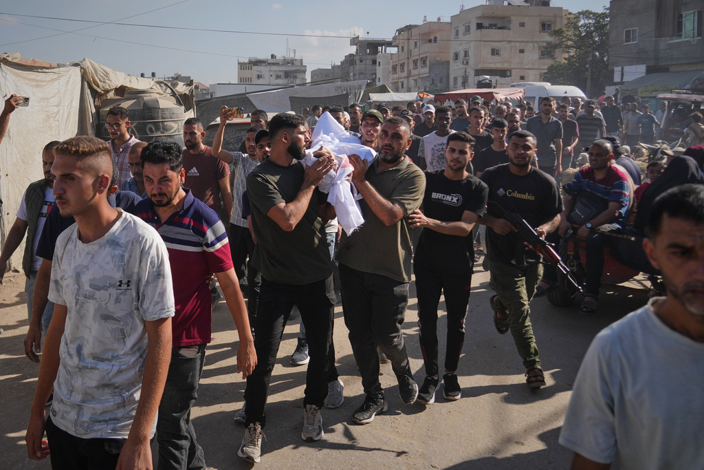 Palestinians carry the body of a man killed in an Israeli strike on Deir al-Balah, Gaza Strip, Wednesday, Oct. 1, 2025. (AP Photo/Abdel Kareem Hana)