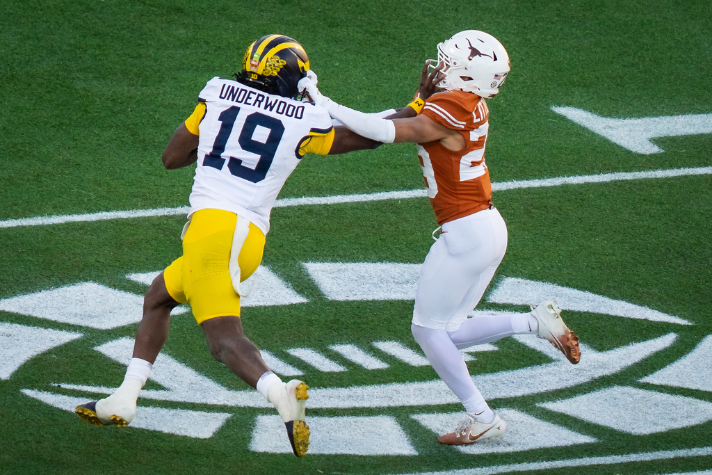 Texas Longhorns defensive back Graceson Littleton (29) defends as Michigan Wolverines quarterback Bryce Underwood (19) runs the ball in the second quarter of the Citrus Bowl against the Wolverines at Camping World Stadium in Orlando, Fla, Dec. 31, 2025. (Sara Diggins/Austin American-Statesman via AP)