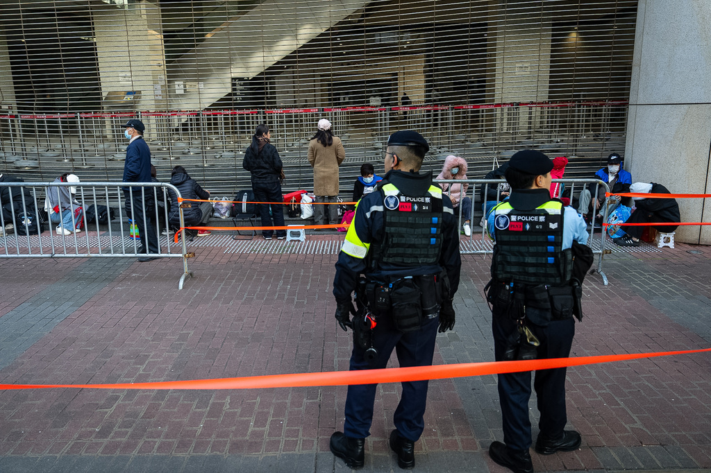 People wait to enter the West Kowloon Magistrates' Courts ahead of the verdict for Hong Kong activist publisher Jimmy Lai's national security trial, in Hong Kong, Monday, Dec. 15, 2025. (AP Photo/Chan Long Hei)
