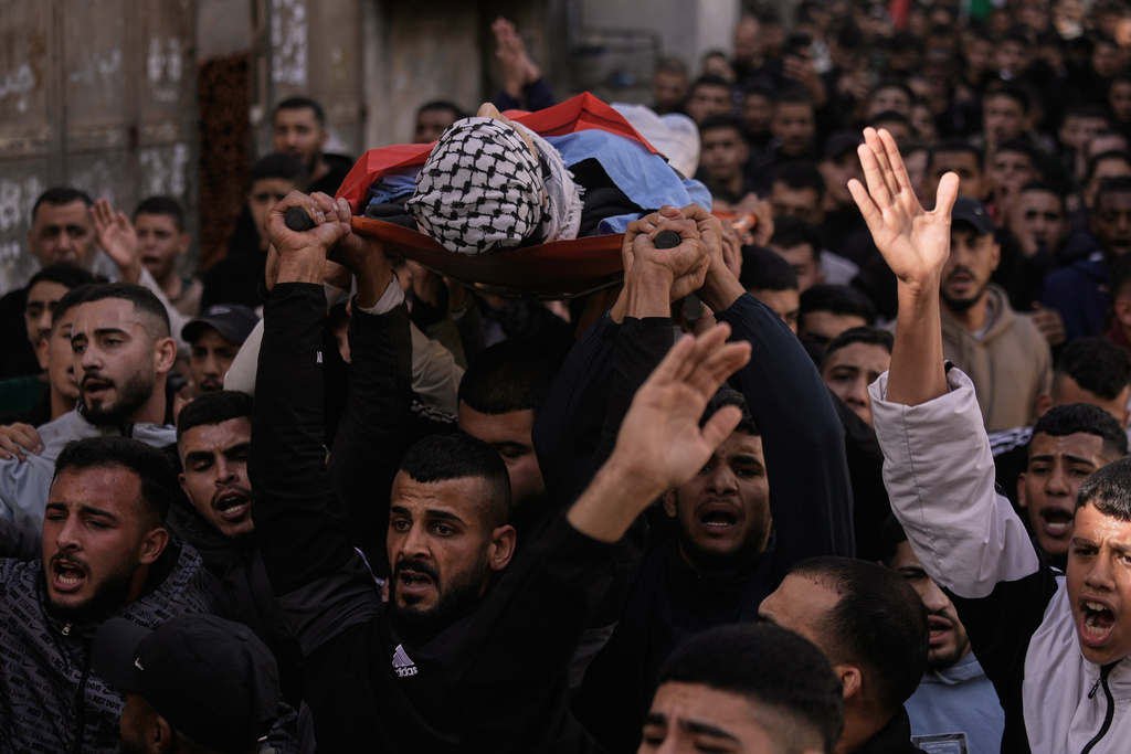 Mourners carry the body of the Palestinian Hassan Ahmed Jamil Moussa,19, who, according to health authorities, was killed during an Israeli raid last night, during his funeral in the Askar camp near the West Bank city of Nablus, Sunday, Nov. 16, 2025. (AP Photo/Majdi Mohammed)