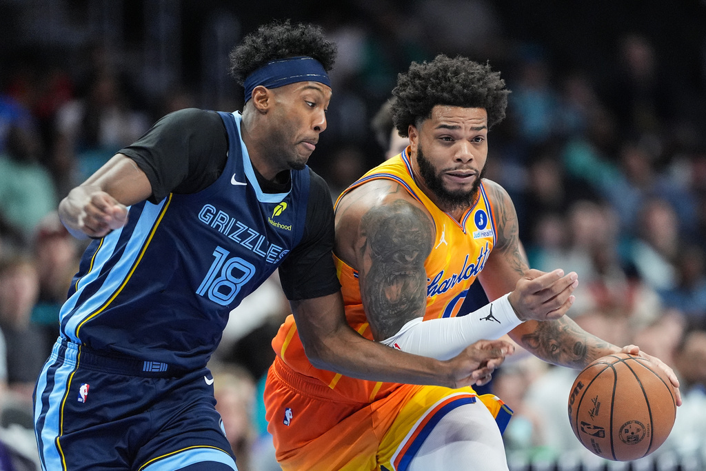 Charlotte Hornets forward Miles Bridges (0) brings the ball up court against Memphis Grizzlies forward Olivier-Maxence Prosper (18) during the first half of an NBA basketball game Saturday, March 21, 2026, in Charlotte, N.C. (AP Photo/Matt Kelley)