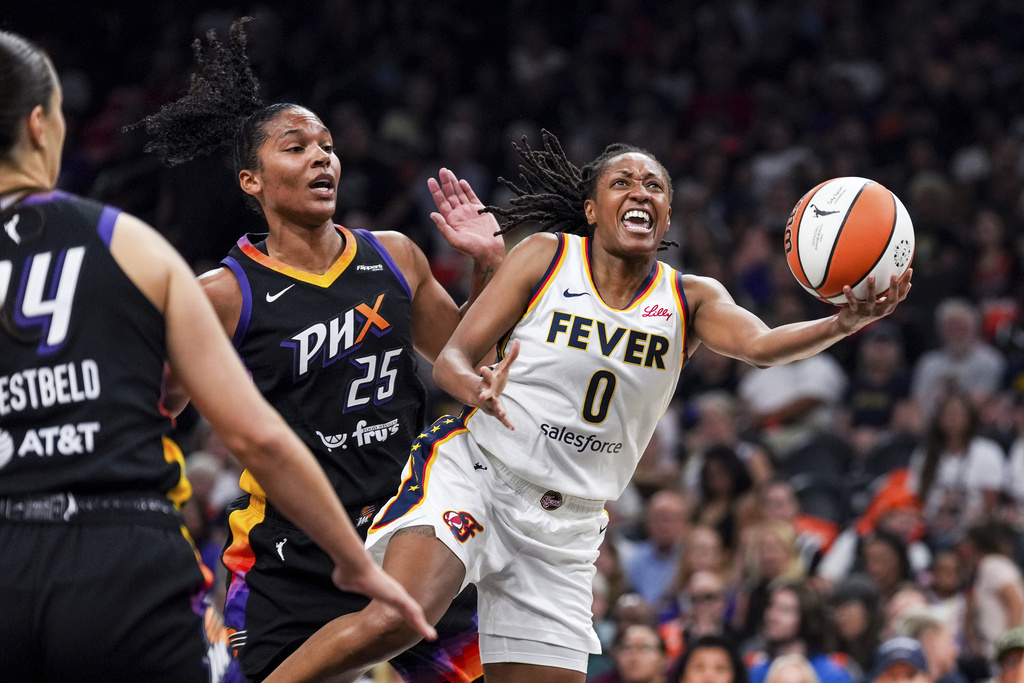 Indiana Fever guard Kelsey Mitchell (0) pushes past Phoenix Mercury forward Alyssa Thomas (25) during the first half of a WNBA basketball game, Tuesday, Sept. 2, 2025, in Phoenix. (AP Photo/Samantha Chow)
