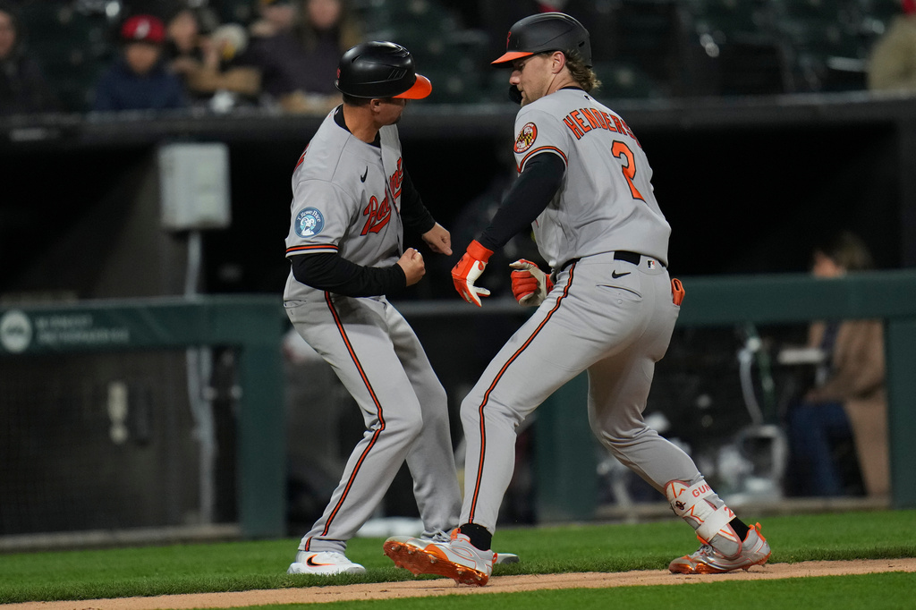 Baltimore Orioles' Gunnar Henderson (2), right, celebrates with third base coach Buck Britton, left, after hitting a home run during the sixth inning of a baseball game against the Chicago White Sox, Monday, April 6, 2026, in Chicago. (AP Photo/Erin Hooley)