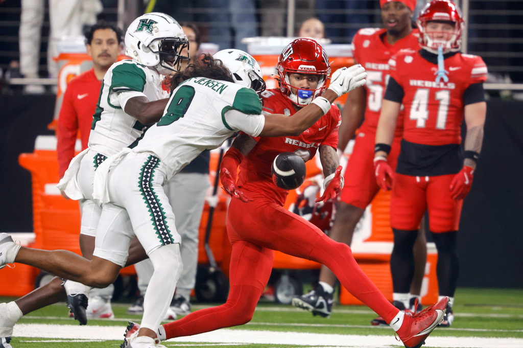 Hawaii defensive backs Devyn King, left, and Kilinahe Mendiola-Jensen (8) break up a pass intended for UNLV wide receiver Jaden Bradley (6) during the first half of an NCAA college football game Friday, Nov. 21, 2025, in Las Vegas. (Steve Marcus/Las Vegas Sun via AP)