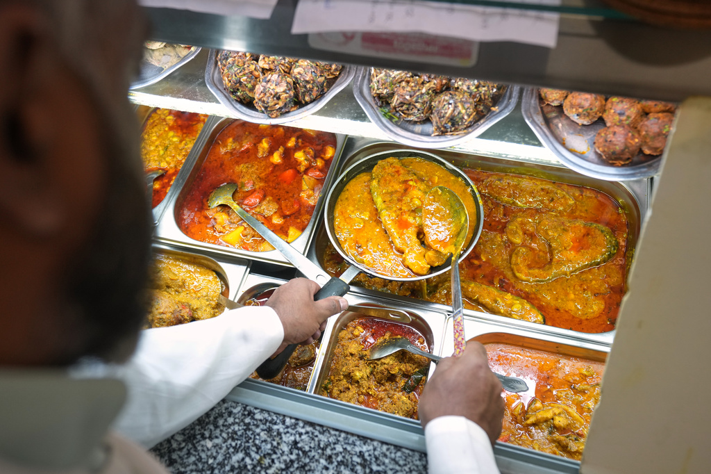 Chef Mohammed Shanoor Ali prepares food at a Bangladeshi restaurant in London, Thursday, June 18, 2026. (AP Photo/Kin Cheung)