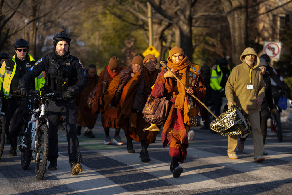 Buddhist monks who are participating in a Walk For Peace walk through a neighborhood on Tuesday, Feb. 10, 2026, in Washington. (AP Photo/Mark Schiefelbein)