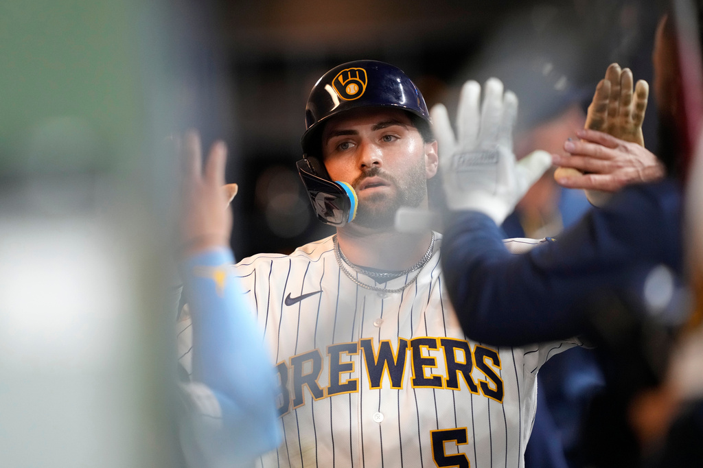 Milwaukee Brewers' Garrett Mitchell high-fives teammates after scoring on a single hit by Joey Ortiz (3) during the seventh inning of a baseball game against the Chicago White Sox, Saturday, March 28, 2026, in Milwaukee. (AP Photo/Kayla Wolf)