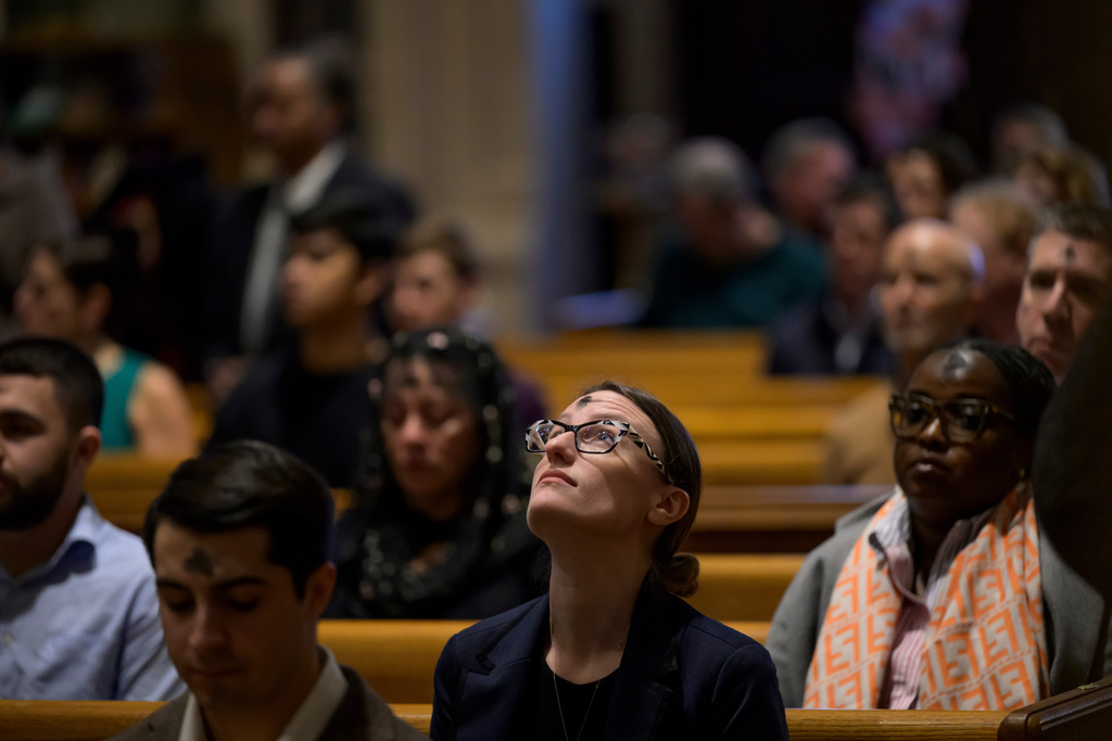 Erica Smeltzer looks up in the pew after receiving ashes during an Ash Wednesday Mass at the Cathedral of St. Matthew the Apostle, Wednesday, Feb., 18, 2026, in Washington. (AP Photo/Rod Lamkey, Jr.)