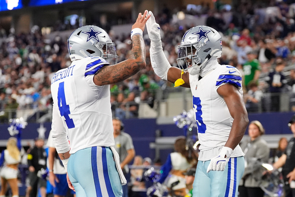 Dallas Cowboys wide receiver George Pickens (3) celebrates his touchdown catch with quarterback Dak Prescott (4) during the first half of an NFL football game Sunday, Nov. 23, 2025, in Arlington, Texas. (AP Photo/Tony Gutierrez)